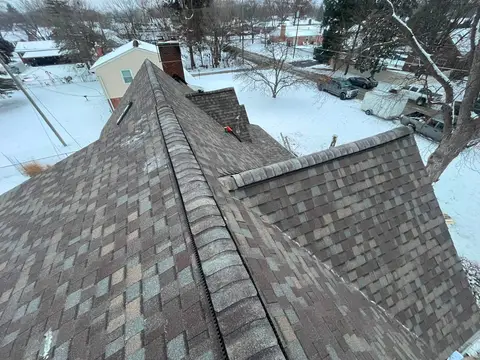 Aerial view of a snowy roof with asphalt shingles