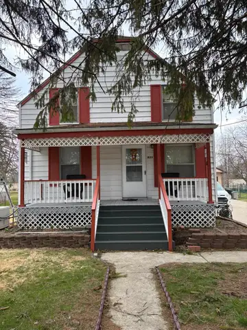 Two-story home with red shutters and porch in Metro Detroit