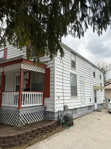 Side view of a two-story home needing roofing repairs